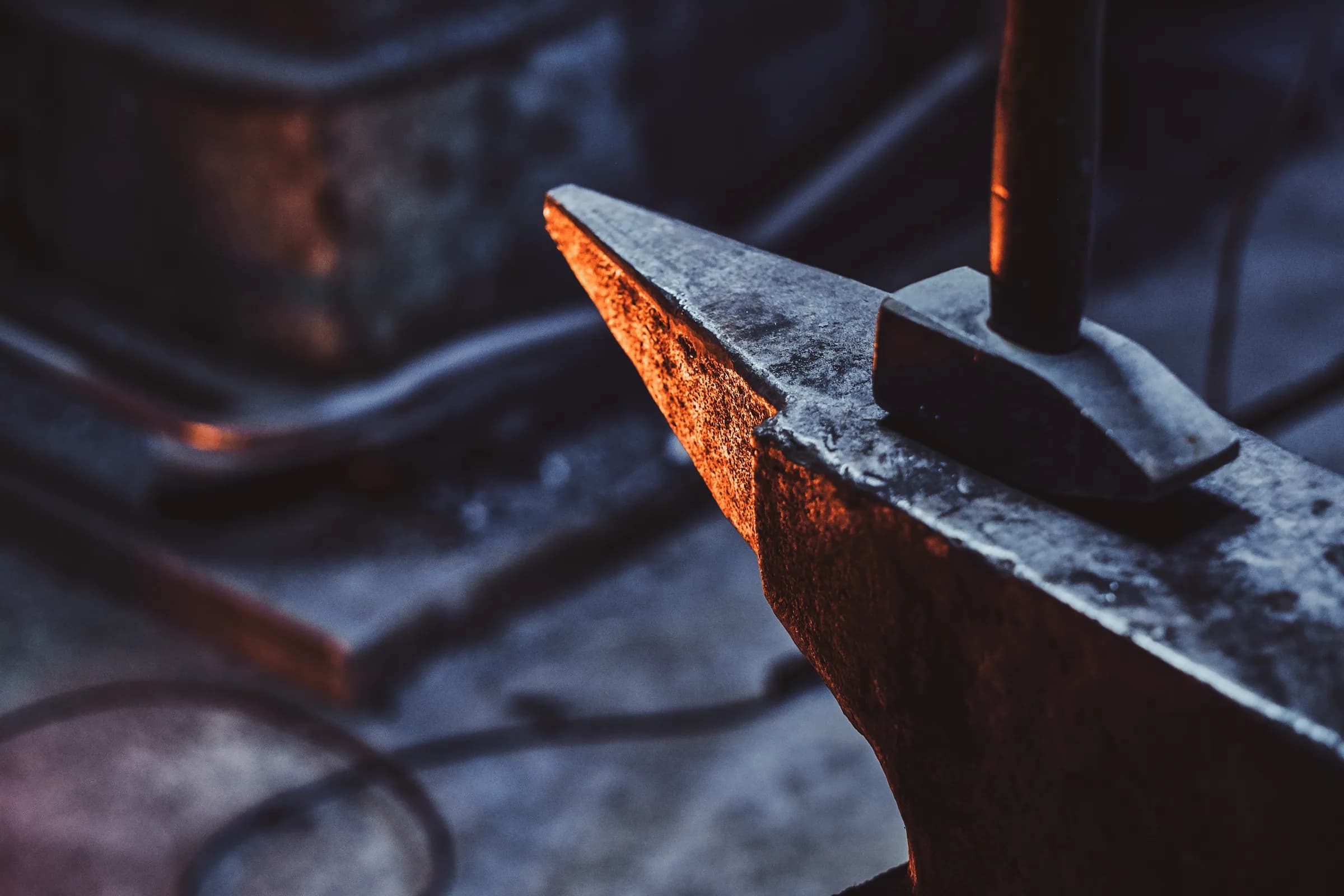 Hammer and anvil in a dark smith's workshop