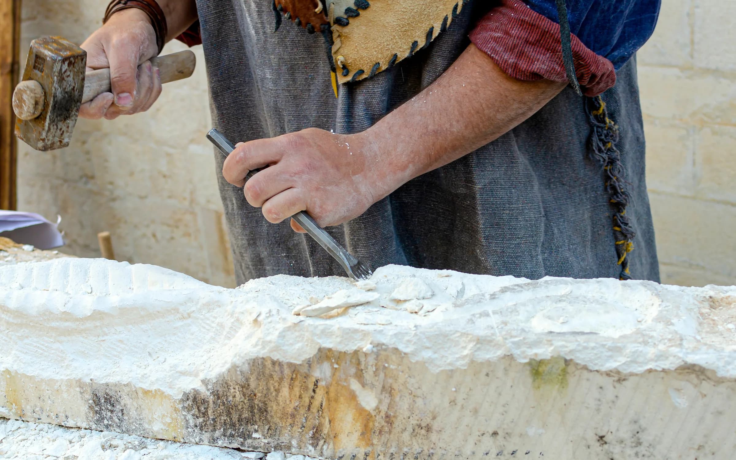Stonemason working stone with a chisel